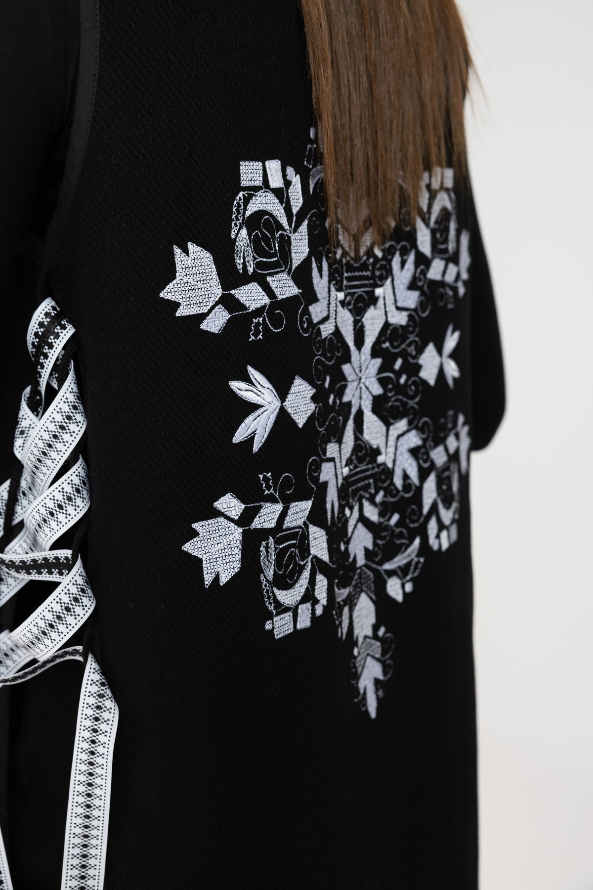 Black woolen midi vest with white floral embroidery and stripes on the side